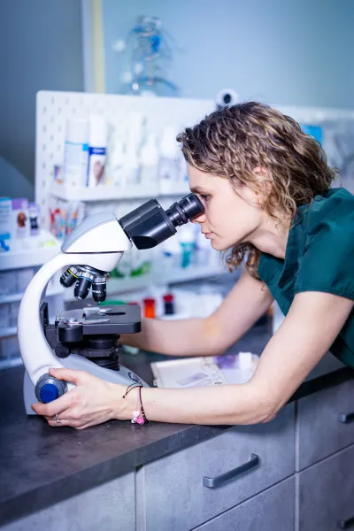 Gydytoja Ilona tiria mėginį mikroskopu klinikos laboratorijoje