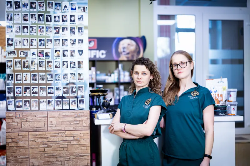 Klinikos komanda – gydytojos Ilona ir Lina prie sienos su pacientų nuotraukomis